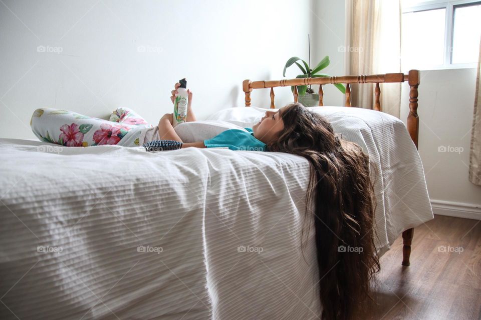 Girl with healthy long hair is using Herbal Essences detangling hair solution