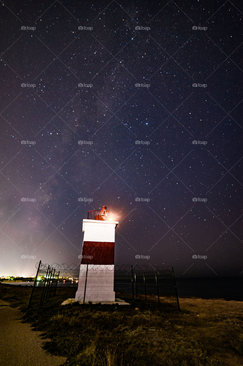 signal lighthouse on the Black Sea coast against the background of the starry sky and the Milky Way