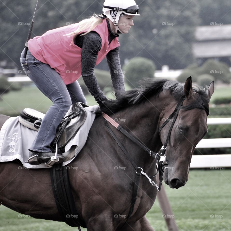 Saratoga Happy.  This female exercise rider has her hands full with this power colt as she trains him during morning workouts at the SPA