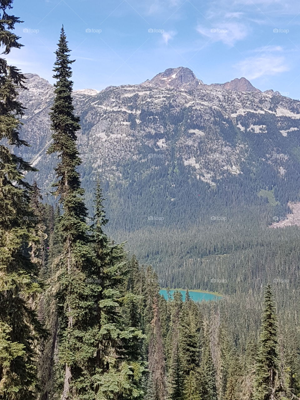 Looking down  from the trail at Joffre Lakes Provincial Park near Pemberton, British Columbia. The stunning turquoise of the lake against the epic glacial mountain  is a visual dream. three lakes create a spectacular journey.