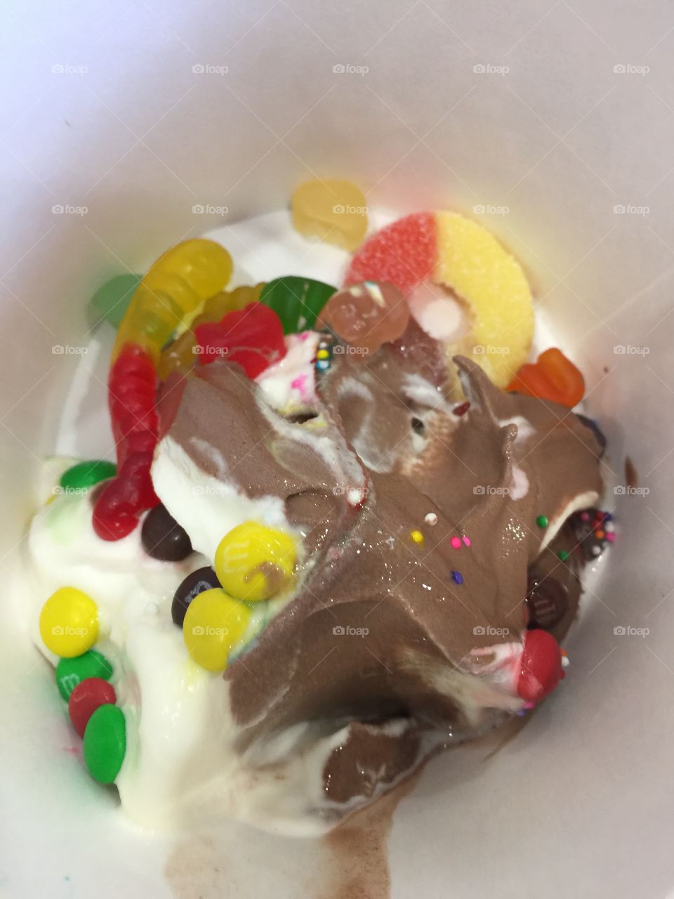 Bowl of Chocolate and vanilla yogurt with candies in it