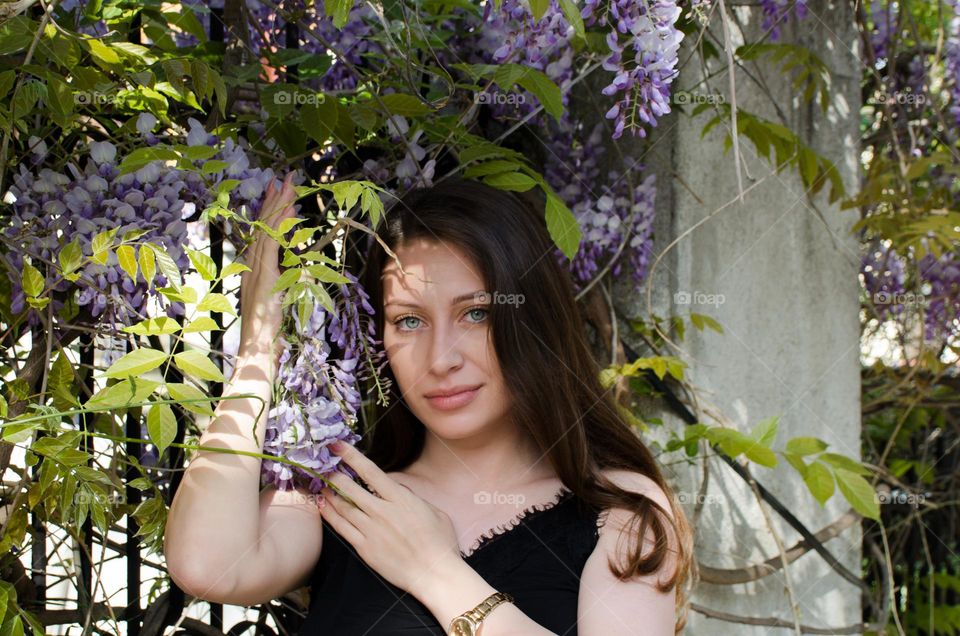 Beautiful Young Girl on Background of Flowers