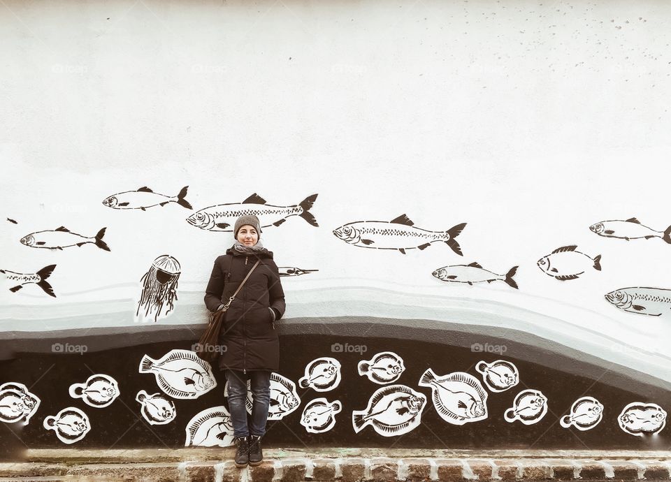 Woman standing near the creative wall