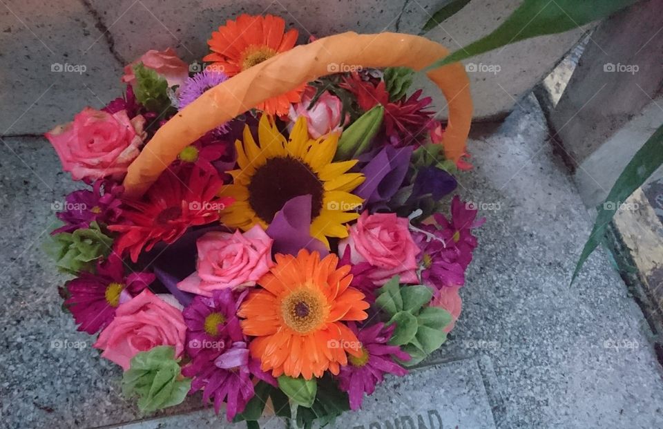 canasta con flores sobre una tumba