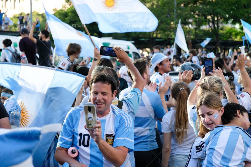 Buenos-Aires - 18.12.2022: Football fans of national team of Argentina in t-shirts on national team celebrating victory on the streets