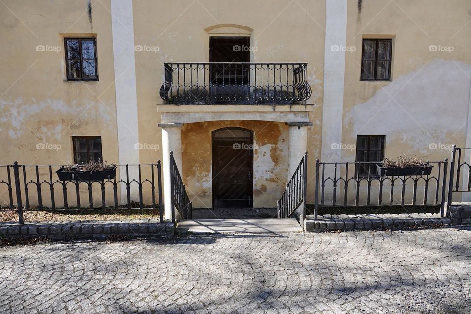 Beautiful spacious balcony with a decorative railing above the entrance of an old building of Lowit's mill in Prague near Palmovka.