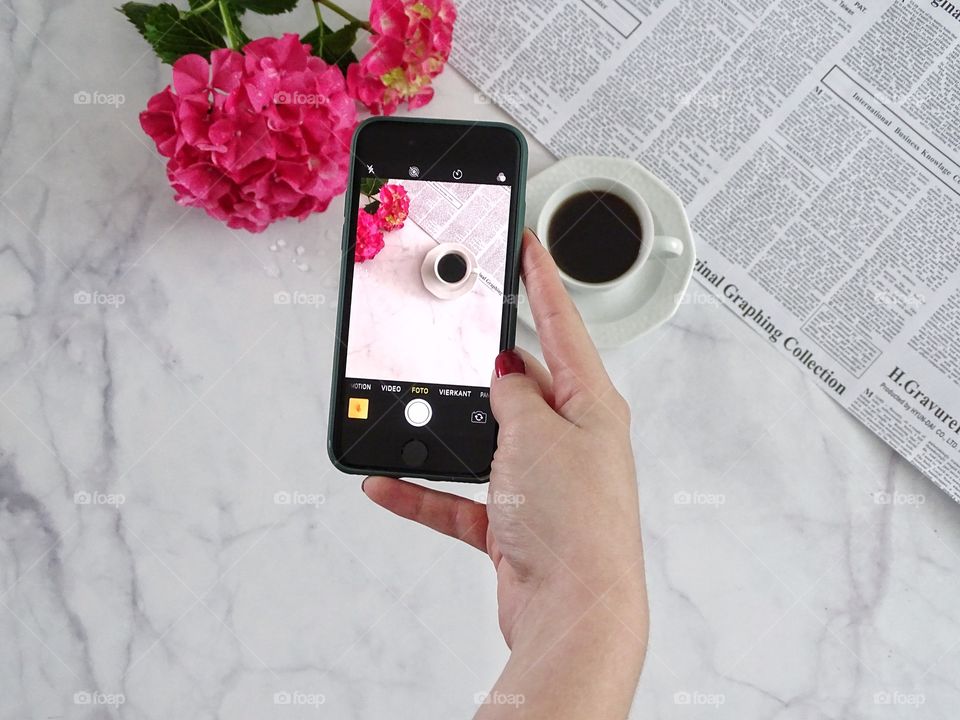 Photographing a black cup of coffee