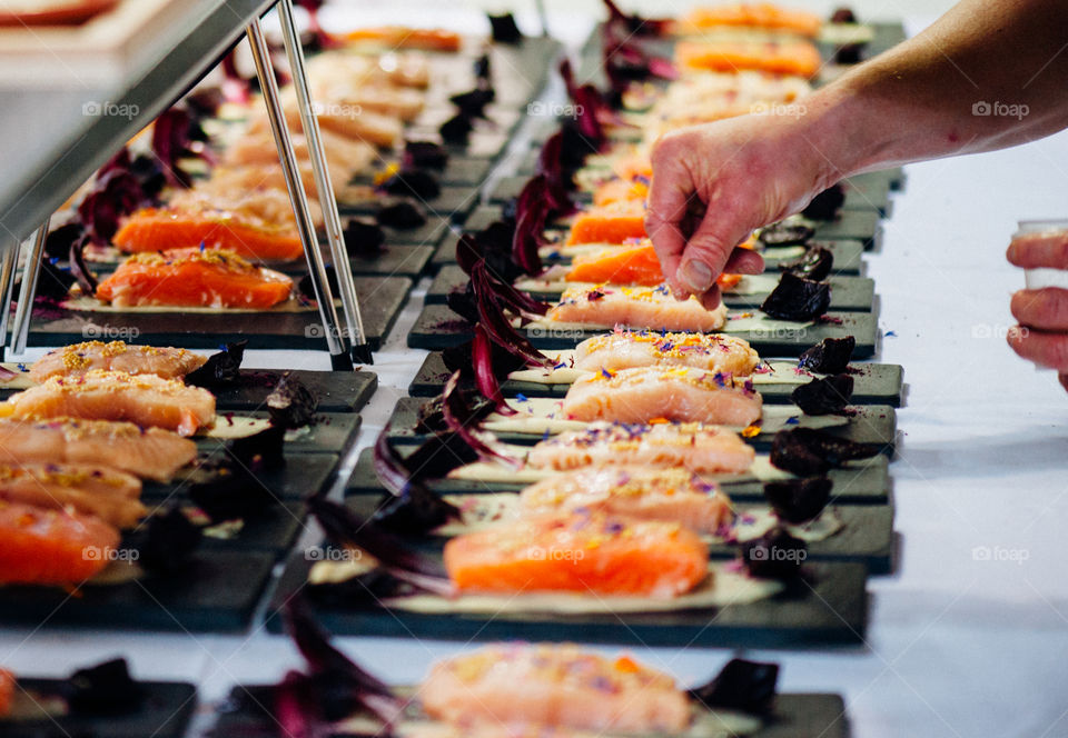 Hands of a chef seasoning food