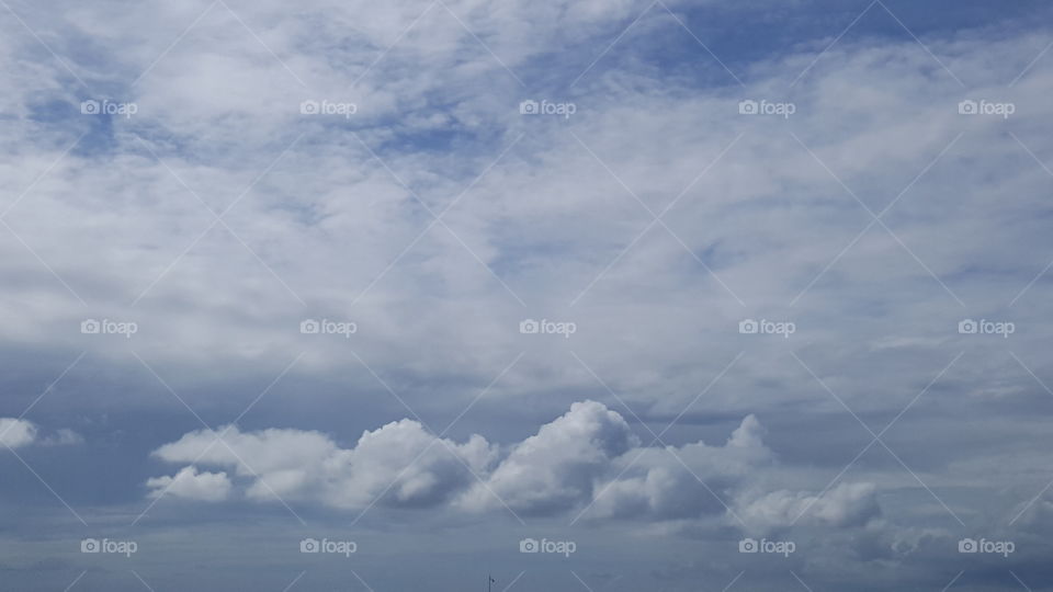 Clouds stretch through an otherwise blue sky.