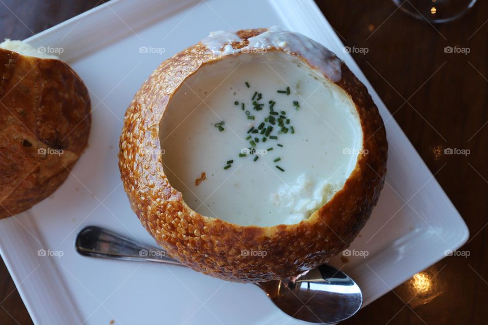 Soup in a bread bowl on white plate