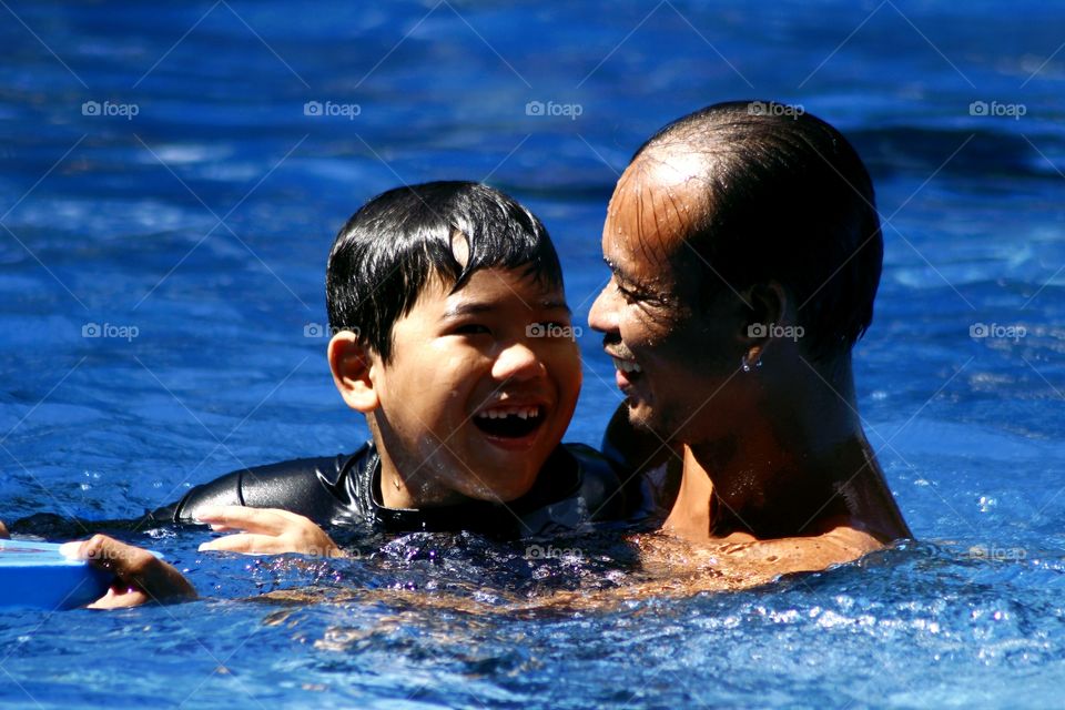 a swimming coach shares a light moment with his student