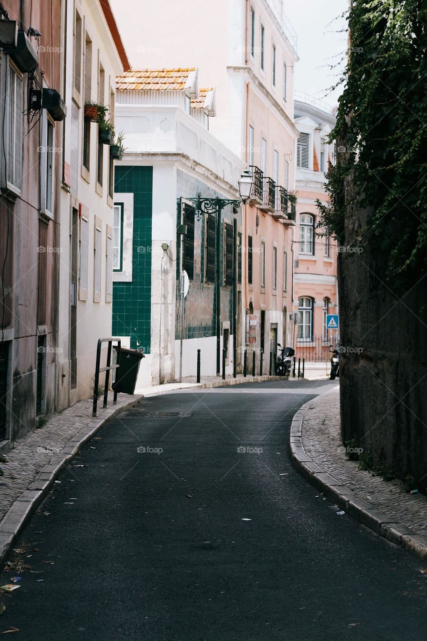 Street in Lisbon, Portugal. Pink and green facades of buildings in Lisbon, no people, street photography.