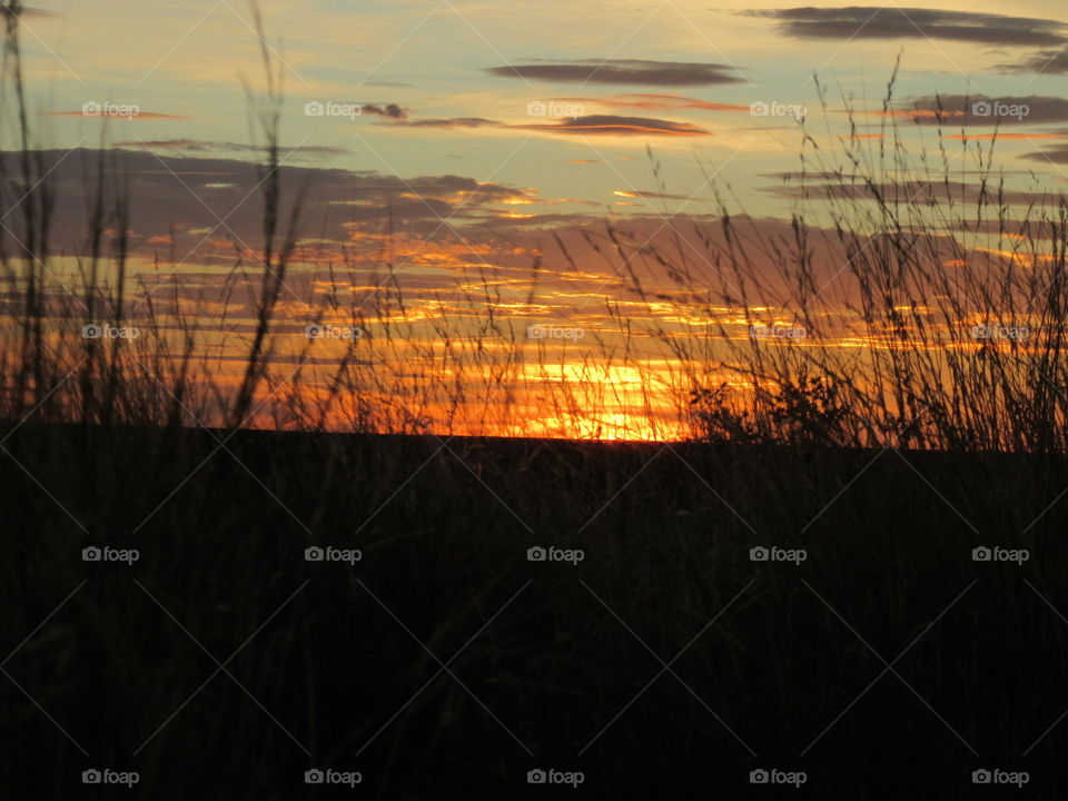 Watching the sun set in a multitude of colors, while sitting in the grass and enjoying the field around you.