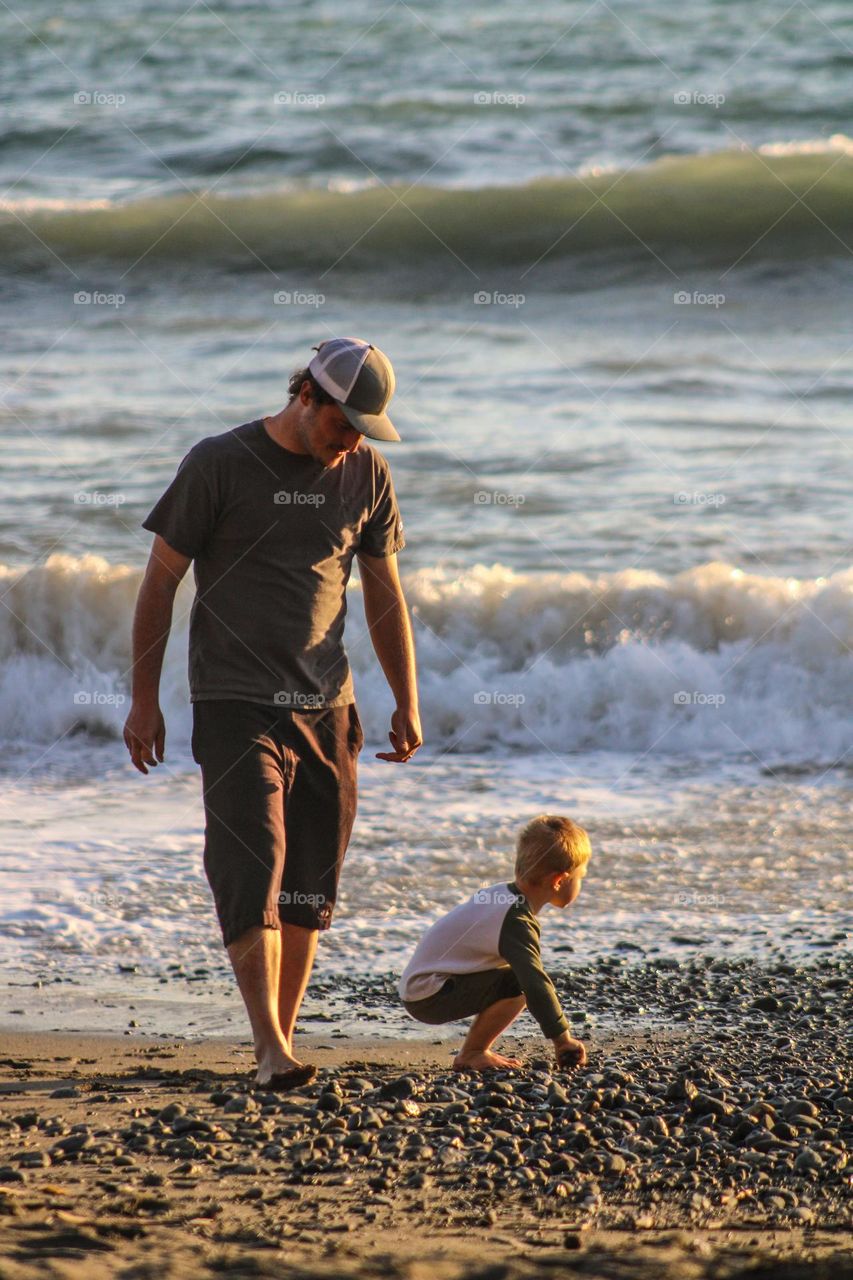 Father and son walking alone the shore in Brookings, Oregon 