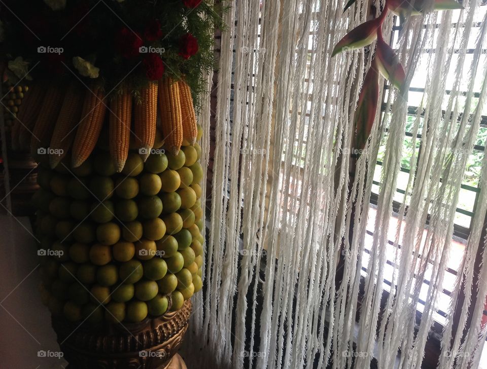 Pillar of fruits and corn. Orange fruits and corn was used to cover the entire pillar to decorate a pillar in a local community hall
