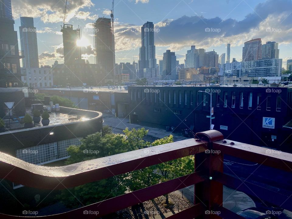This is a view from the “Pulaski Bridge” of “Long Island City” as well as “Manhattan” in the far distance in the soft light of the setting sun during the golden hour. 2023. Hypnotic Productions