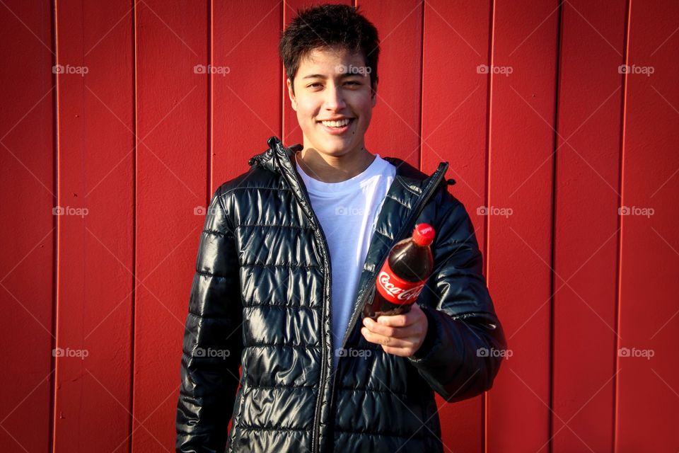 Young handsome man with a bottle of Coca-Cola