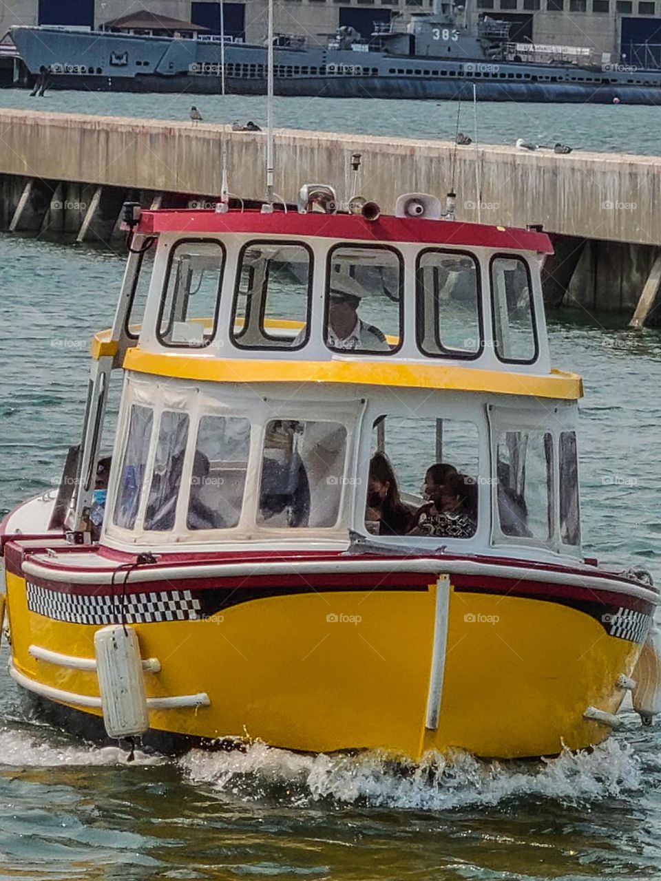 Yellow checkered water taxi transporting passengers from one point in San Francisco to another on the waters of the San Francisco Bay 