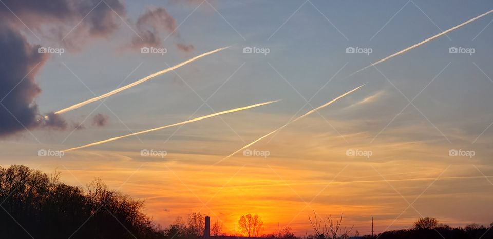 aircraft leave contrails in the sunset