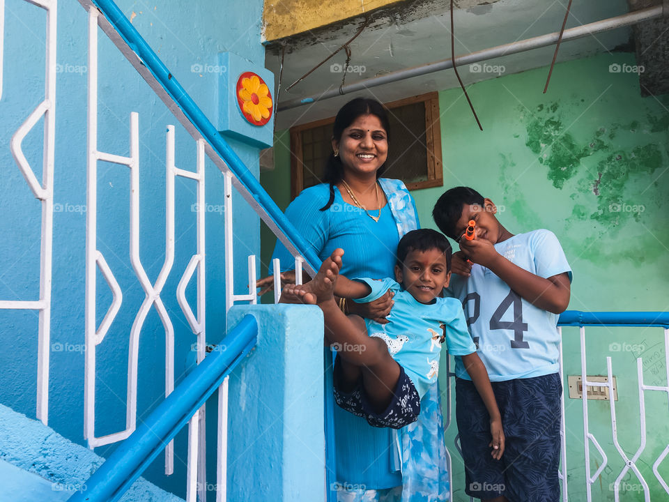 Family in bright blue attire with blue coloured wall