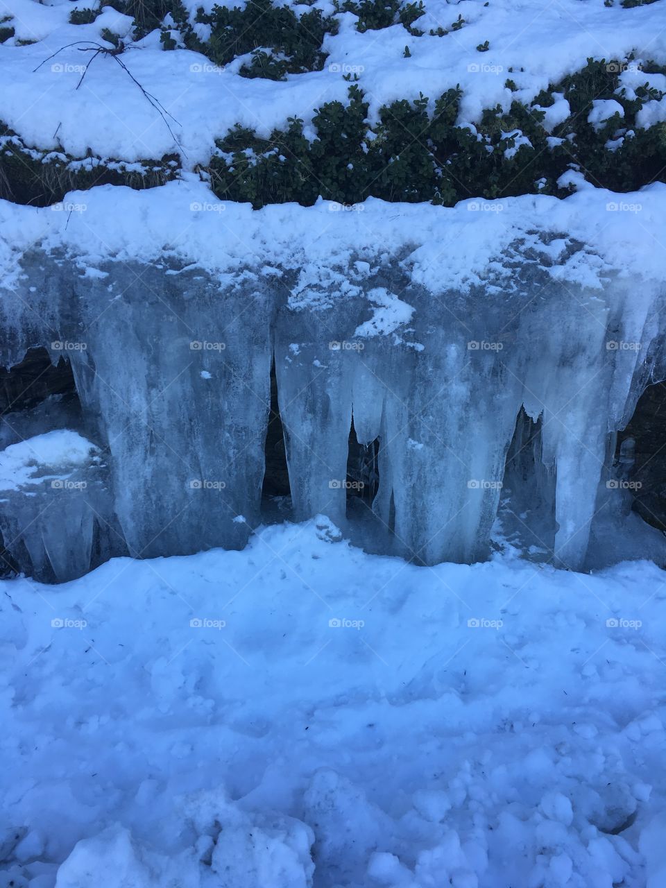 Huge icicles on the side of the road.