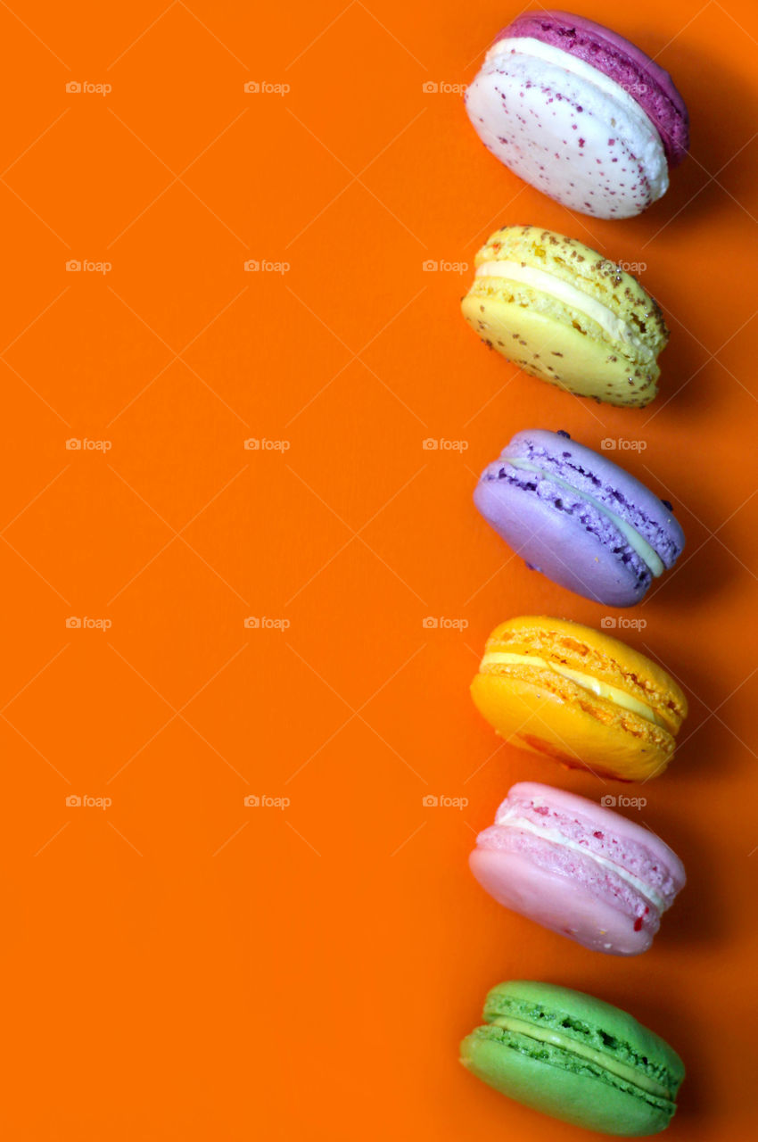 Colorful macaroons on the orange background