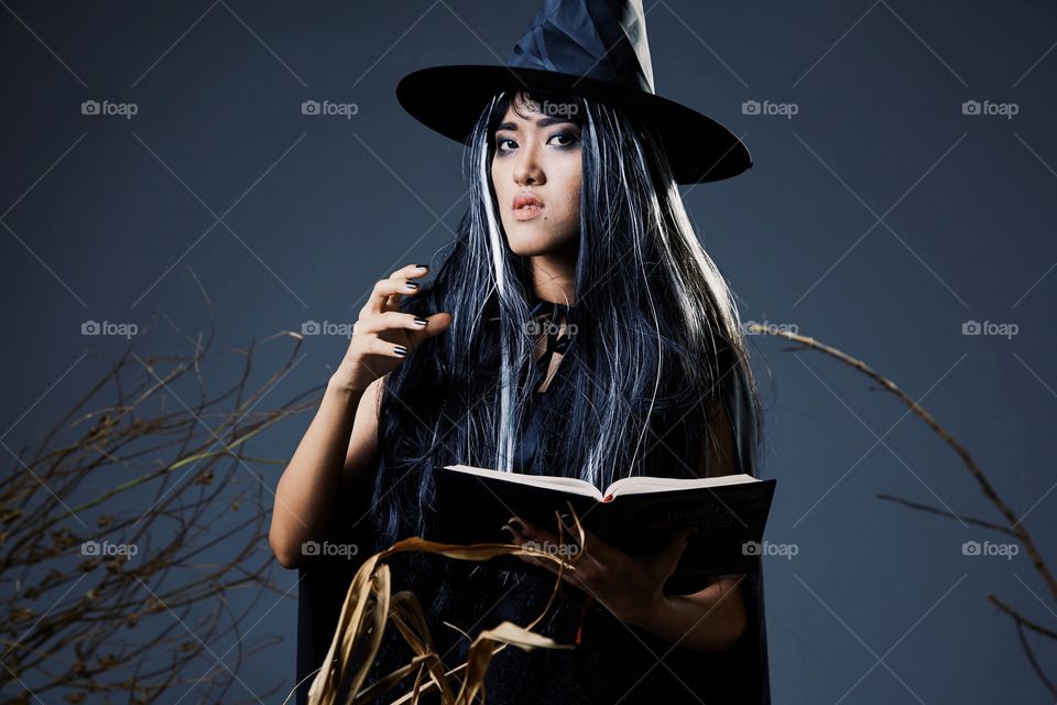 Girl in witch costume with spell book