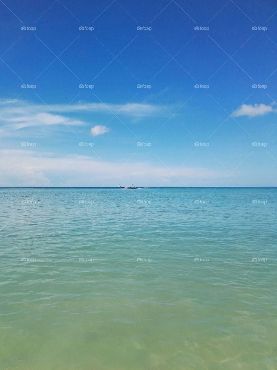 Boat on the horizon. Blue sea and water