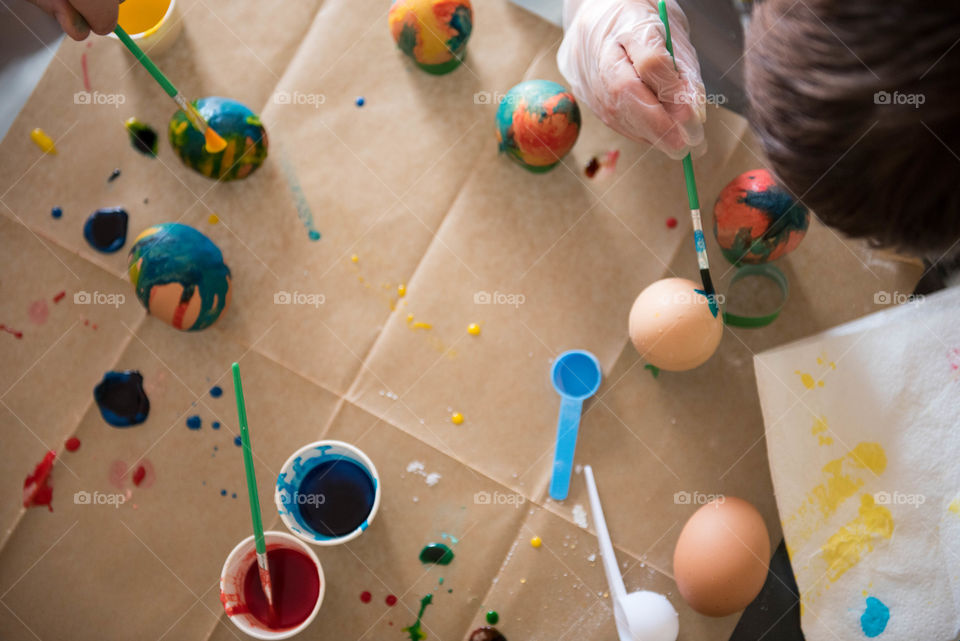 Overhead view of a family painting Easter eggs