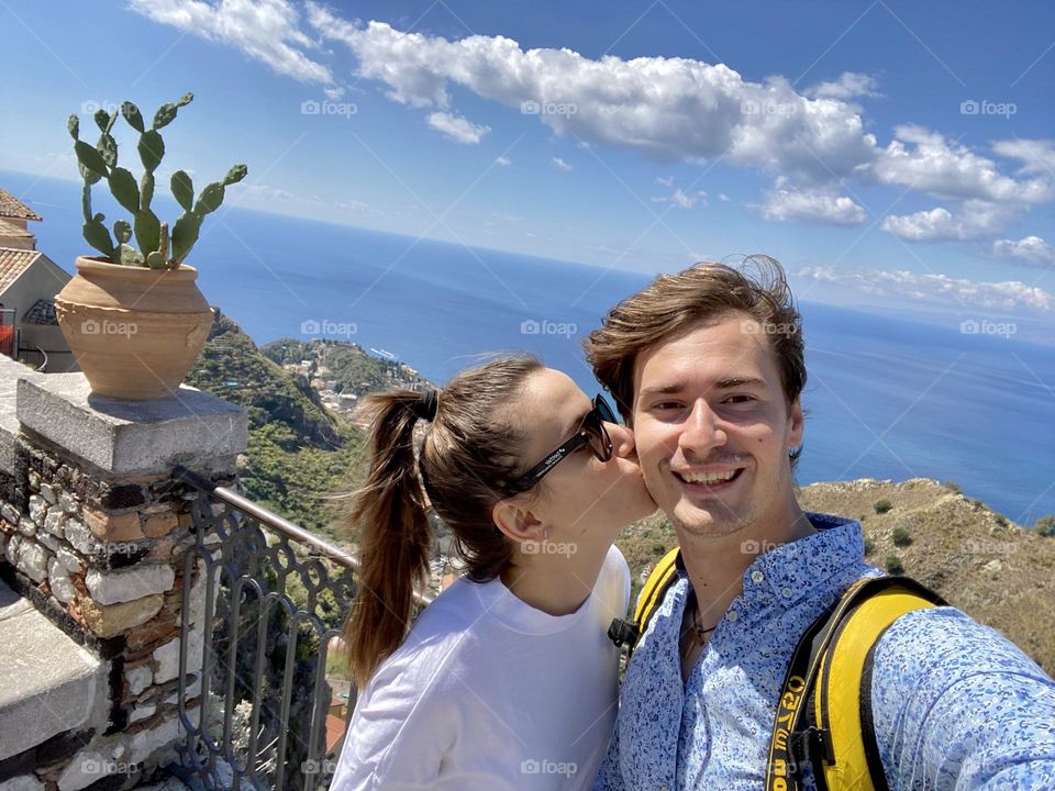 Couple taking a selfie by the seaside in Sicily
