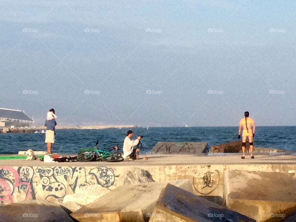 Photo shoot on jetty or pier at El Poblenou beach in Barcelona Spain with people 