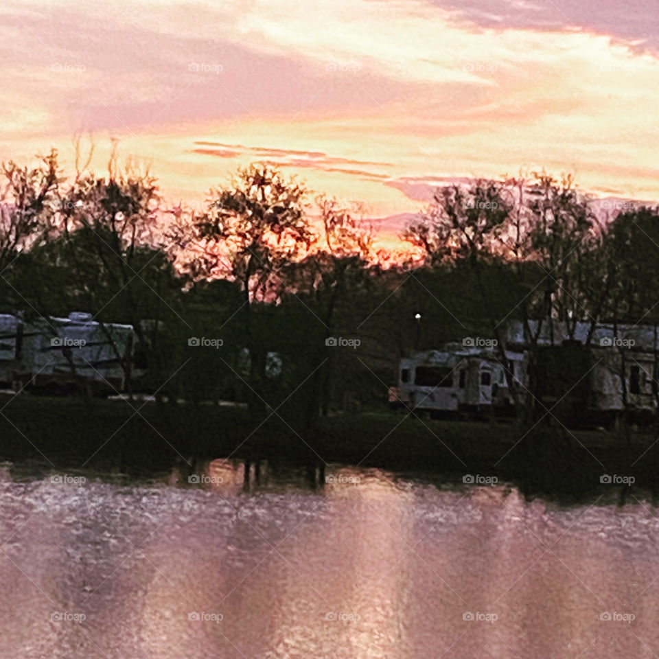 Sundown completed twilight in effect winding down bright colors of blue violet deep pink yellow white all add to the lasting Beauty of this photo not to mention the reflections of the colors on Lake Waters.