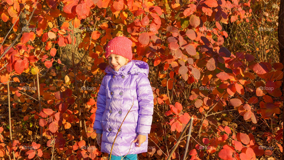 laughing girl against red leaves