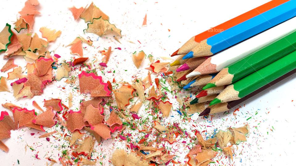 Sharpened colored pencils with shavings on white backgrounds