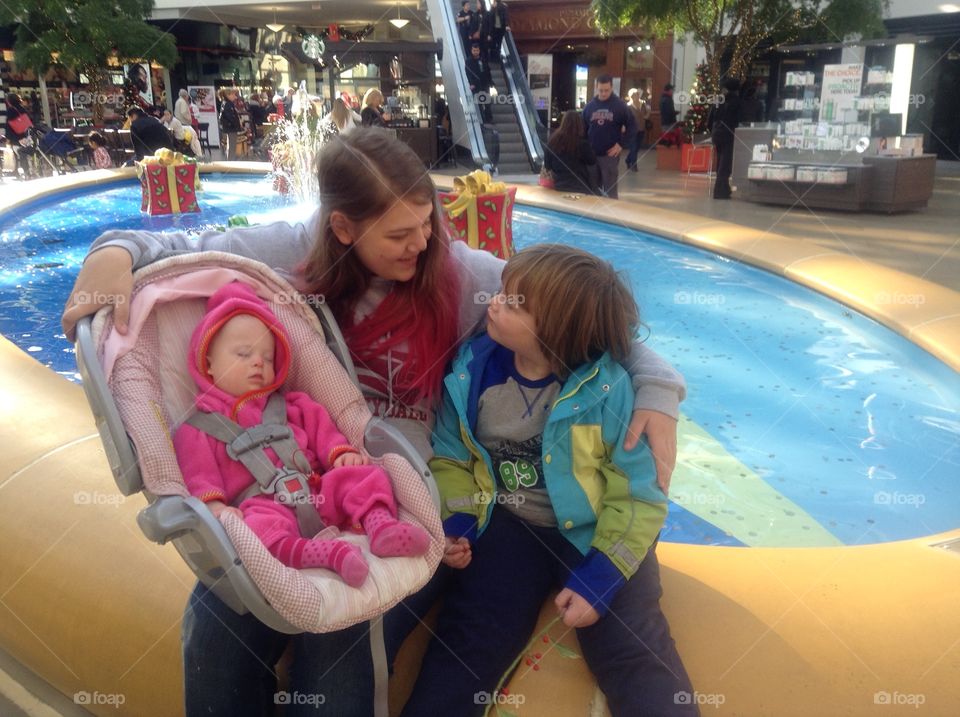 Baby sister with Down syndrome at the mall with her siblings