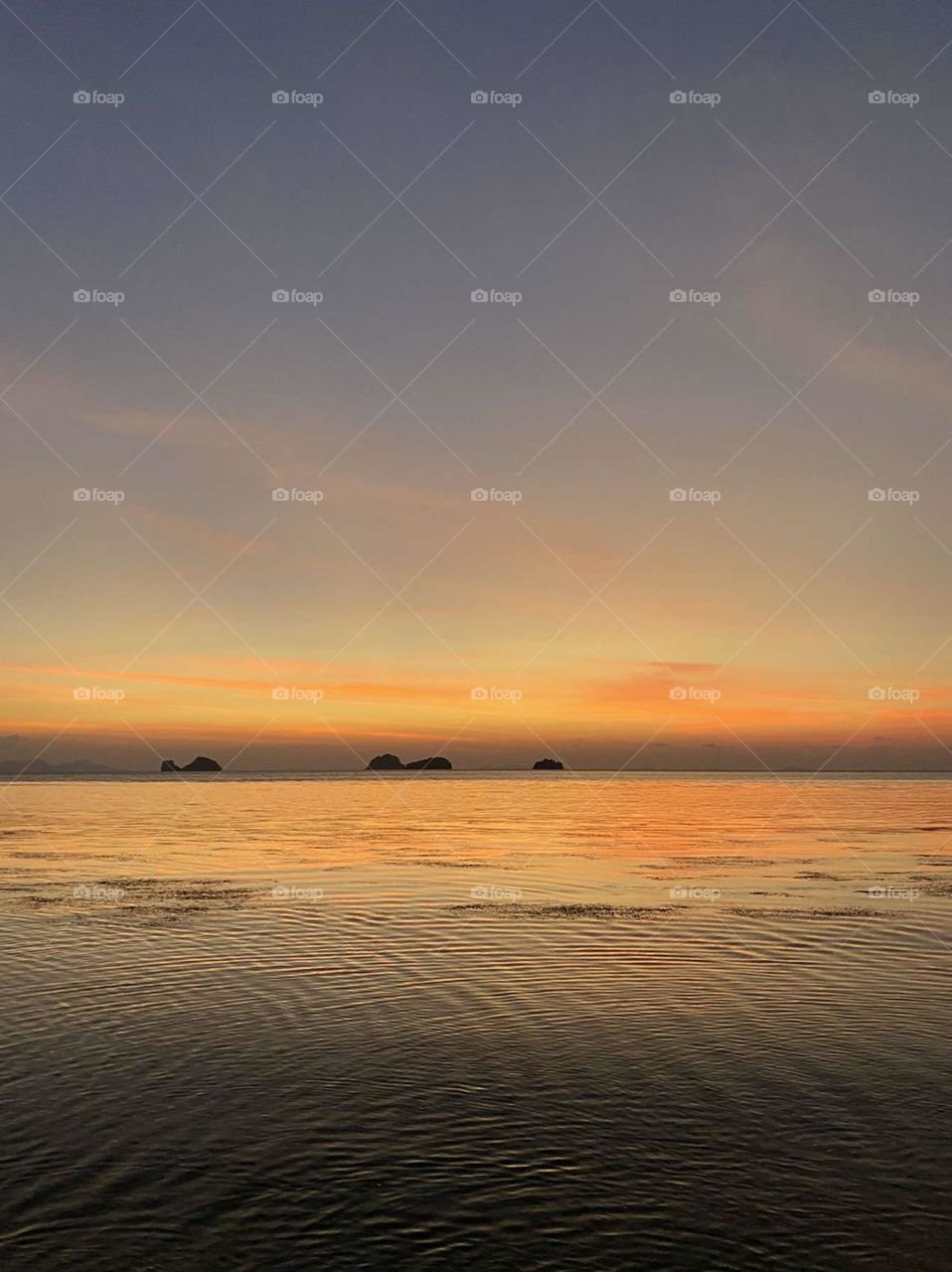 Sunset with a glassy calm sea stretching miles. 