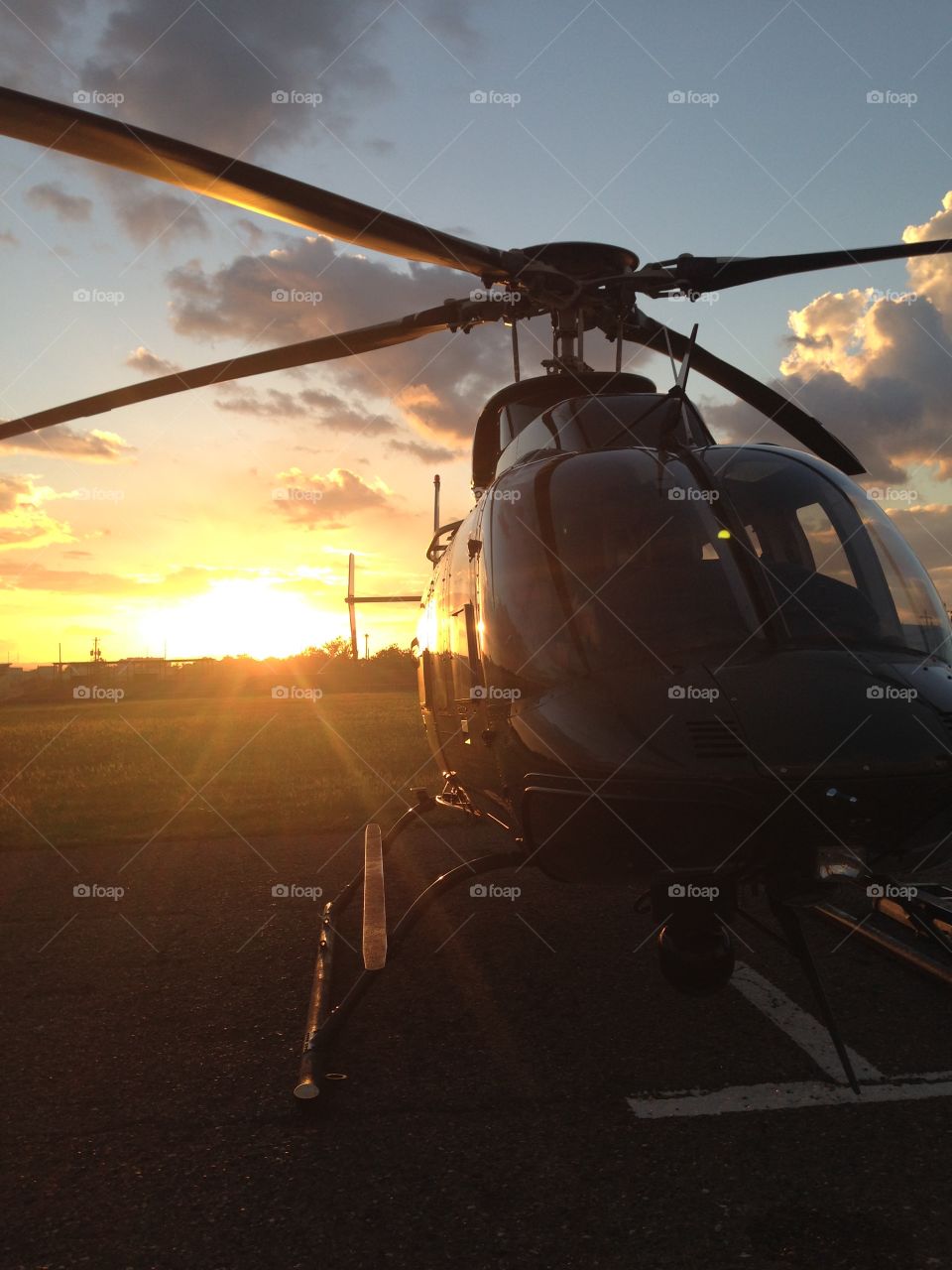 A Bell 407 sitting on the Ramp in Kingston , Jamaica with a beautiful sunset in the background 