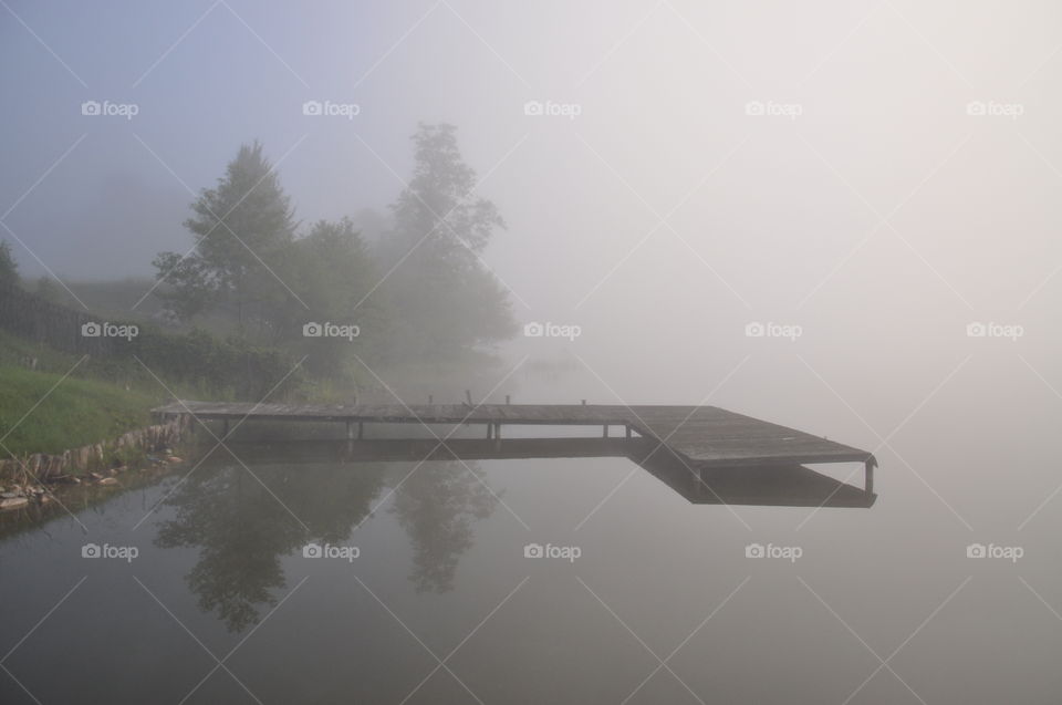 grey foggy morning at the lake in polish countryside