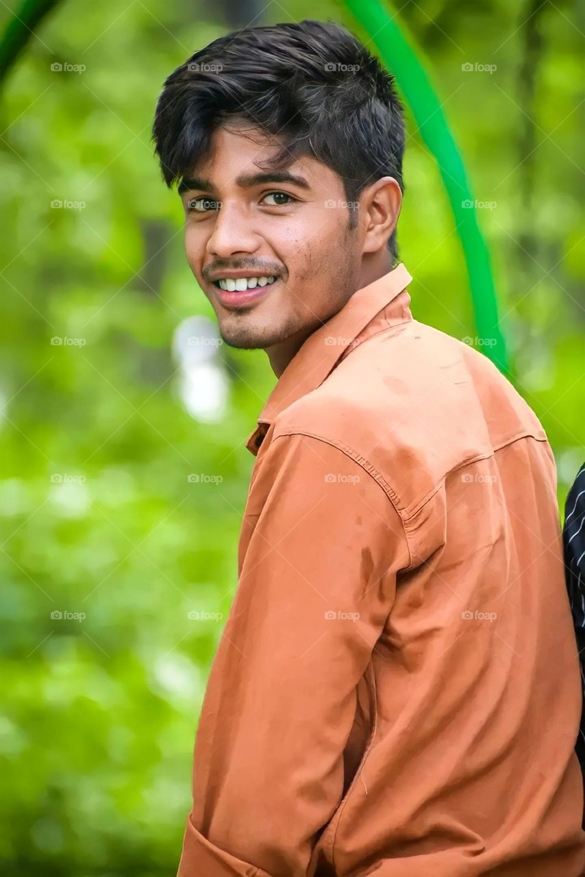 a portrait of Indian boy looking camera with smiley face