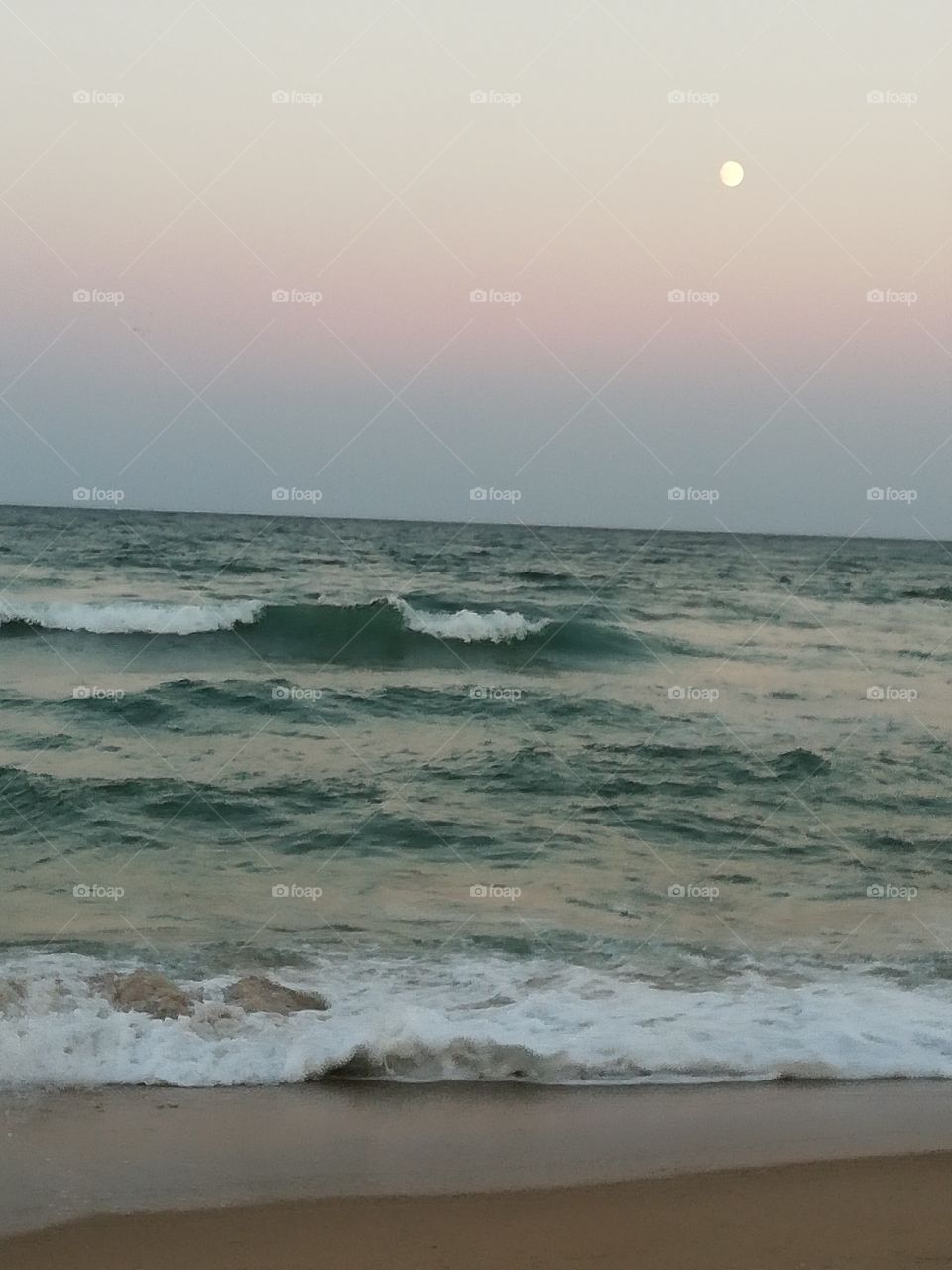 The moon shines over a stormy sea