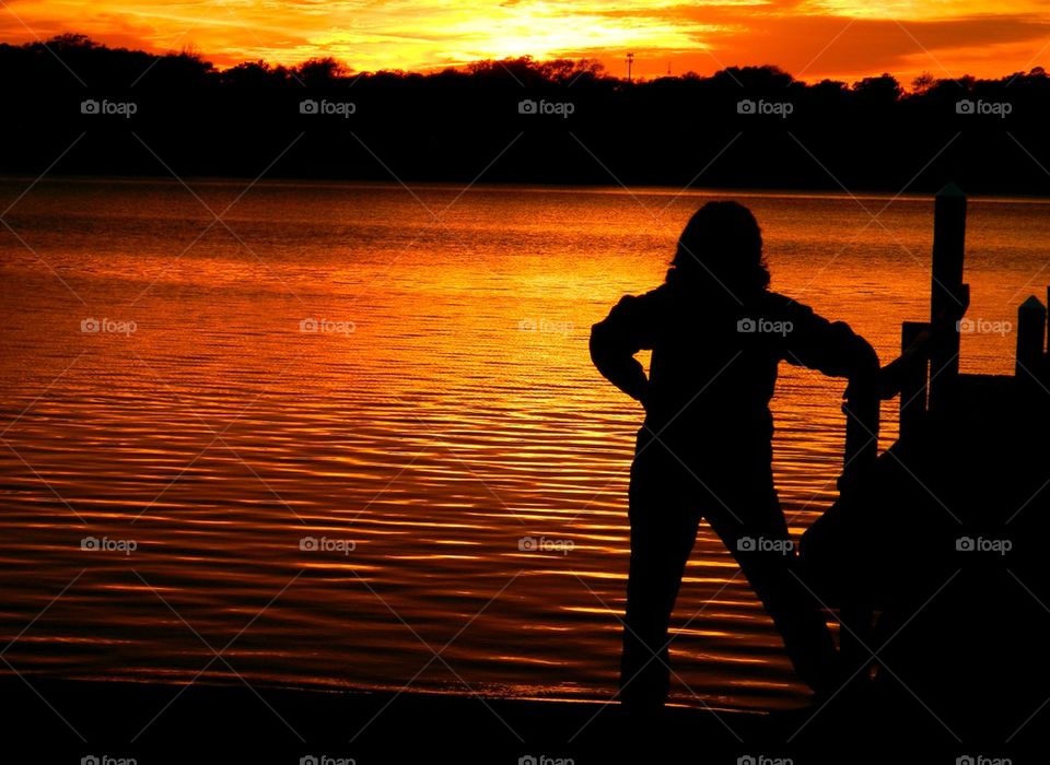 Rear view of woman standing near pier