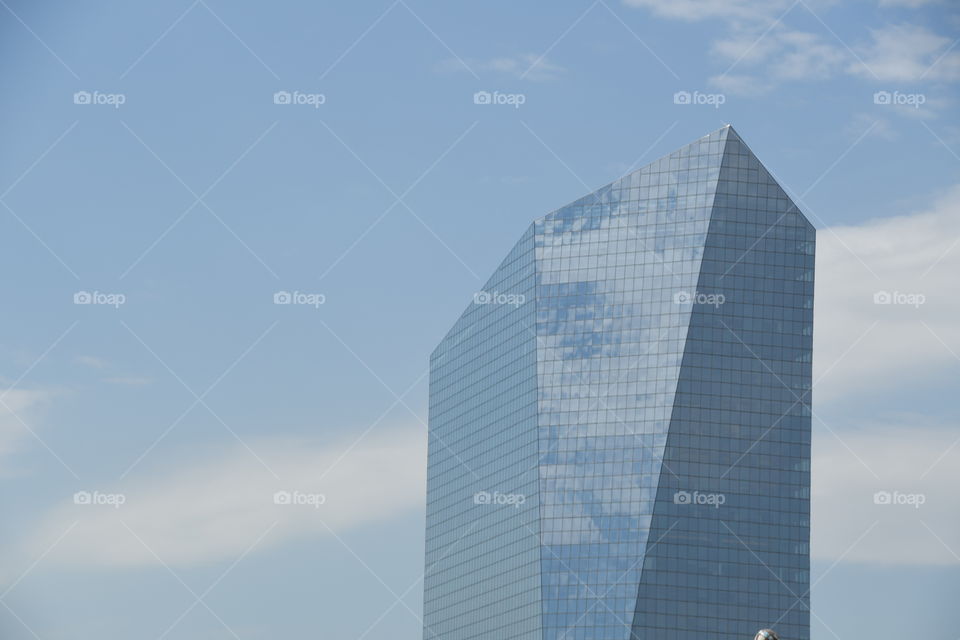 skyscraper with blue sky and cloud reflection