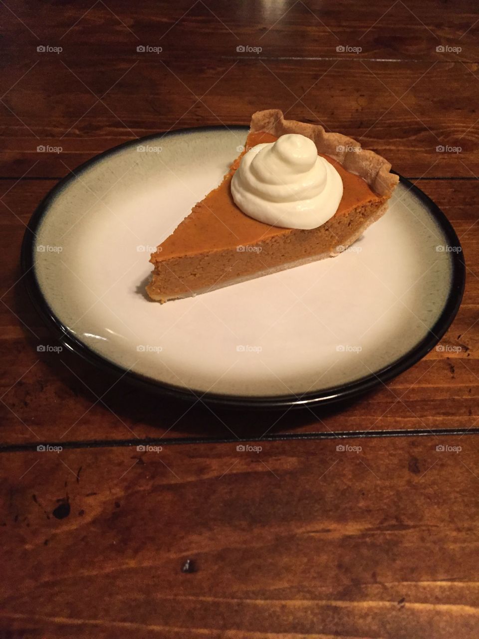 Perfect slice of homemade pumpkin pie with homemade whipped cream