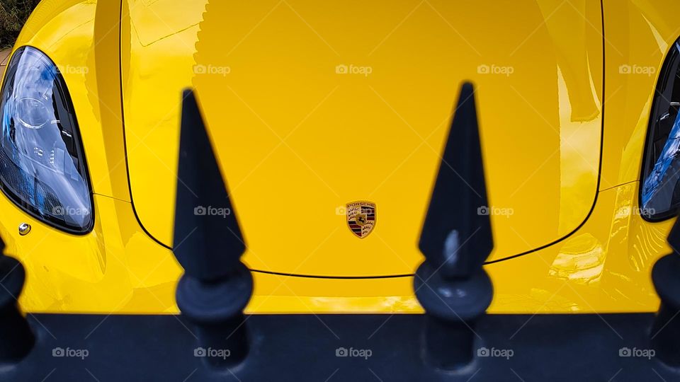 Front end of a bright yellow Porsche sports car.