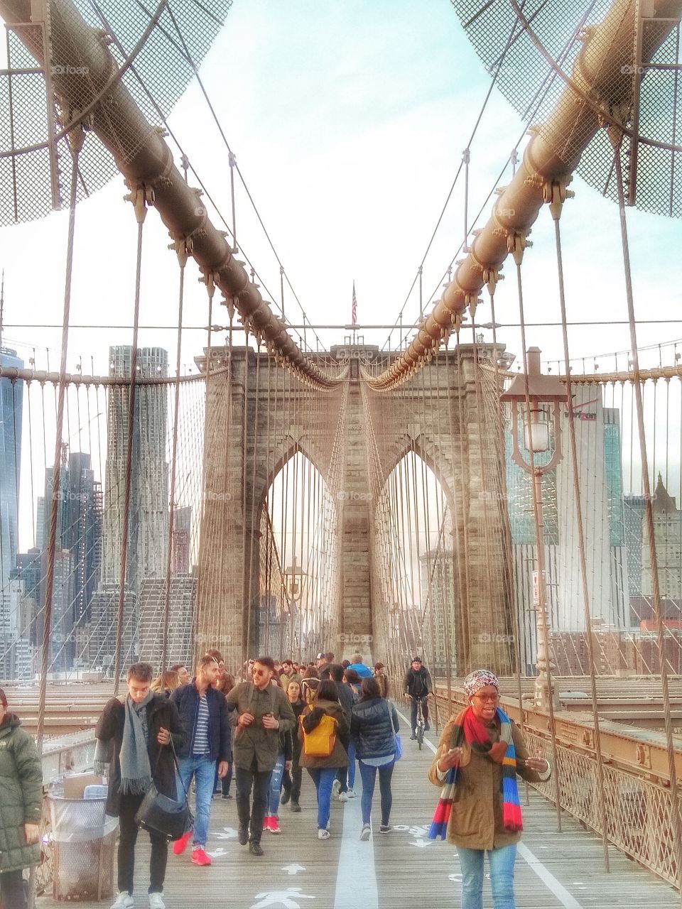unrecognizable people walking Brooklyn bridge
