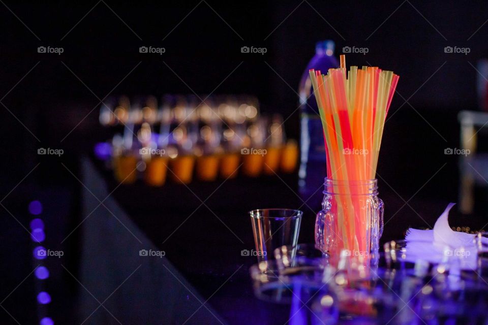 bright colors of cocktail straws for drinks are placed in a glass on the bar