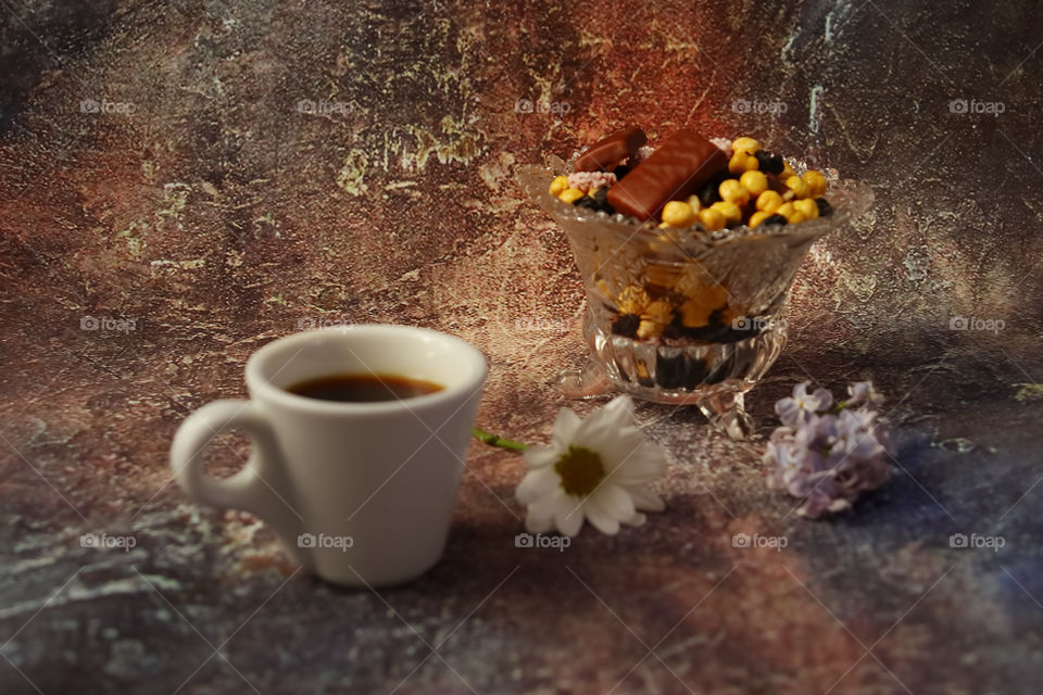 Morning coffee in a hurry a cup of coffee, flowers in a vase, dried fruits and sweets in a vase, a burning candle