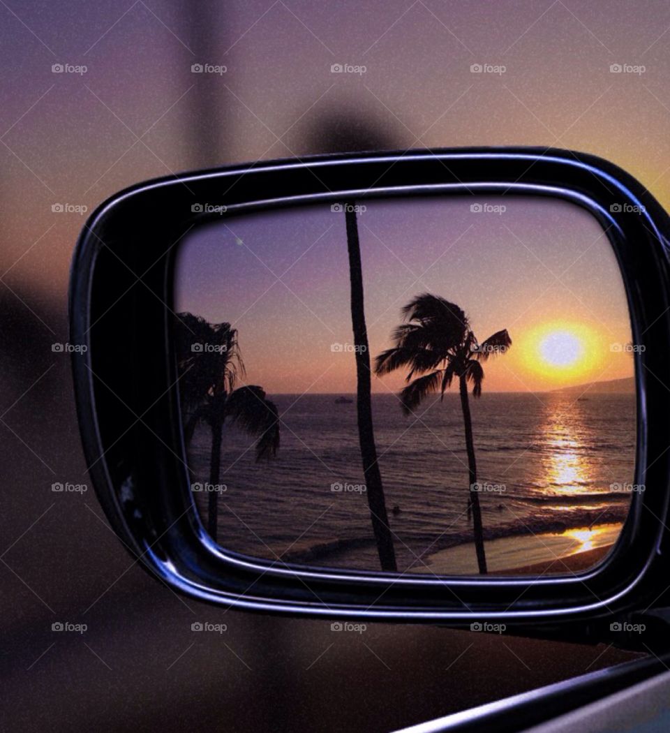 Reflection of sunset in rear view mirror