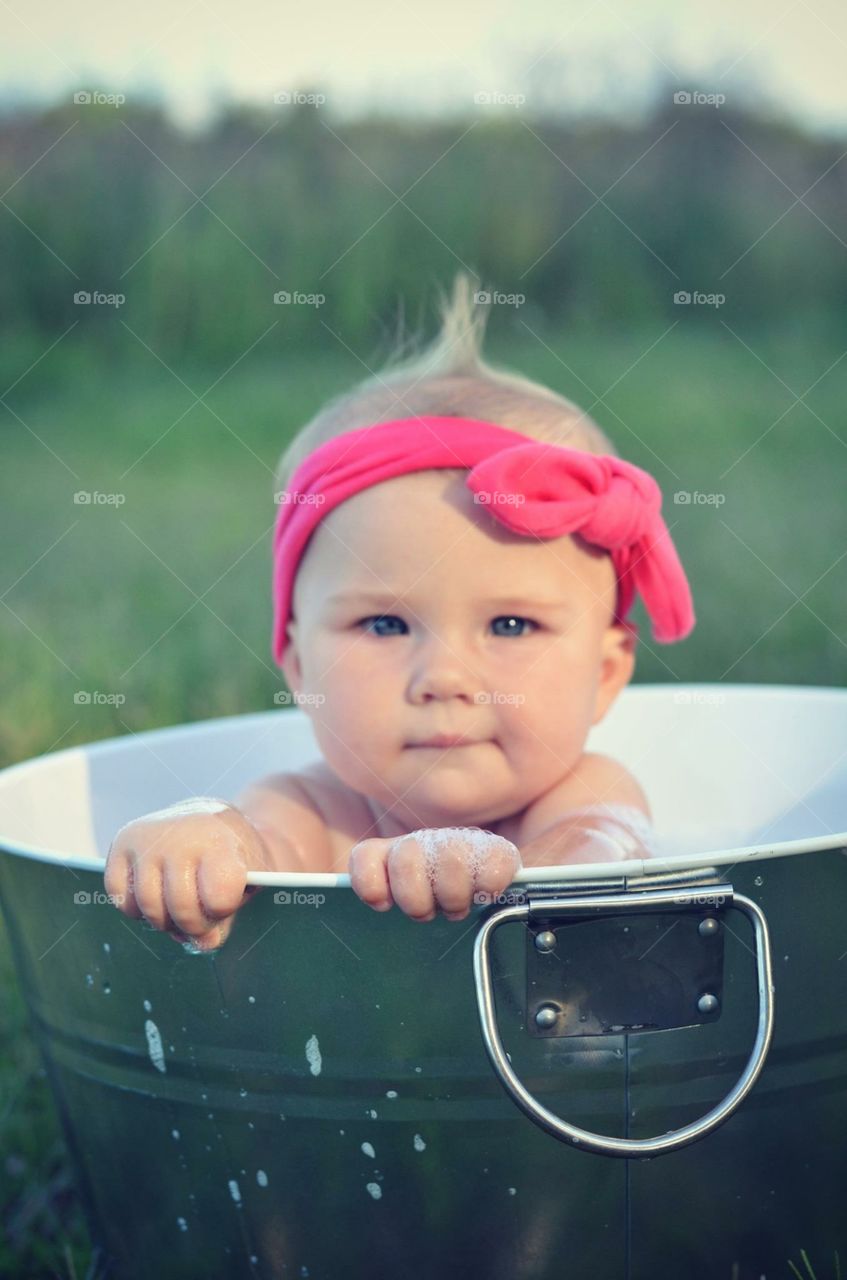 Baby bathing outdoors in tub