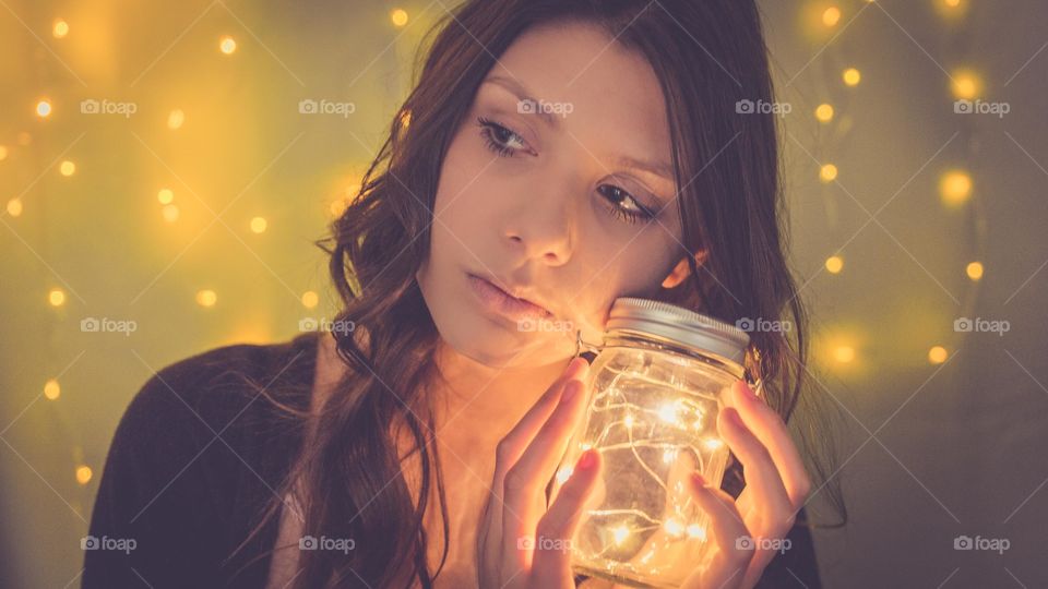 Beautiful woman holding light jar in hand
